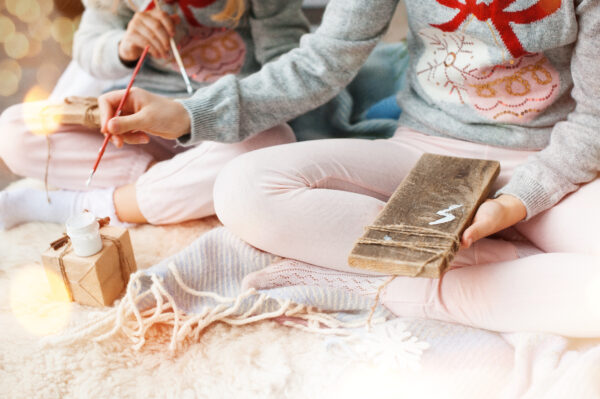 two girls painting on wooden boards. christmas time